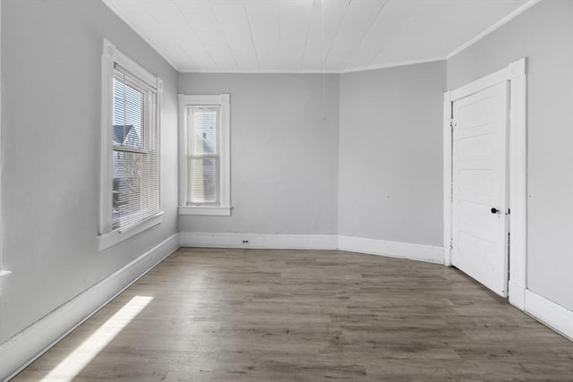 empty room with ornamental molding and dark hardwood / wood-style flooring