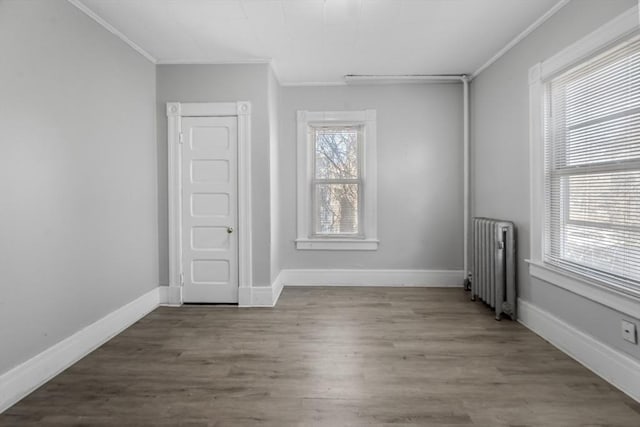 spare room with hardwood / wood-style flooring, ornamental molding, and radiator