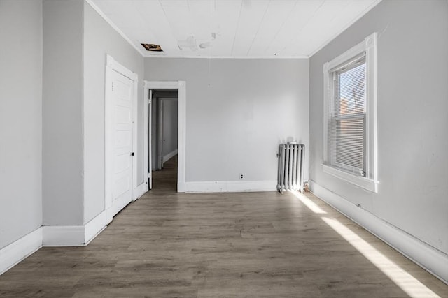 unfurnished room with ornamental molding, dark hardwood / wood-style flooring, and radiator