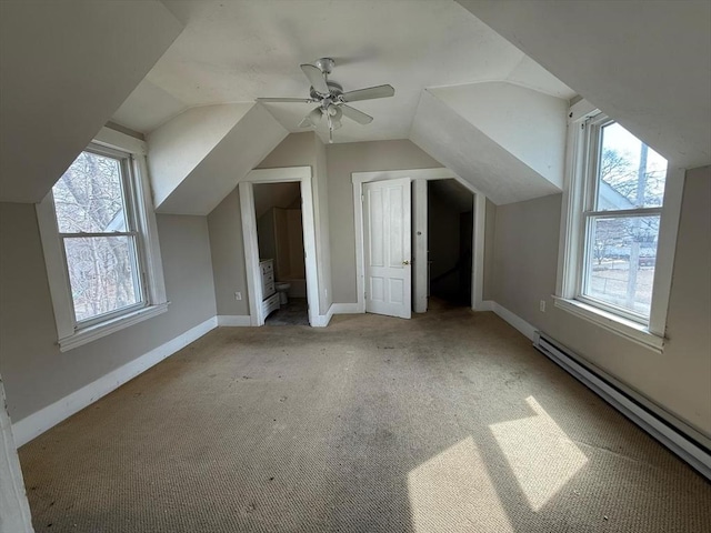 bonus room with vaulted ceiling, carpet flooring, a wealth of natural light, and a baseboard radiator