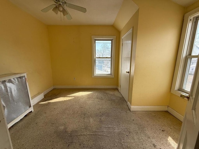 carpeted spare room featuring baseboards and ceiling fan