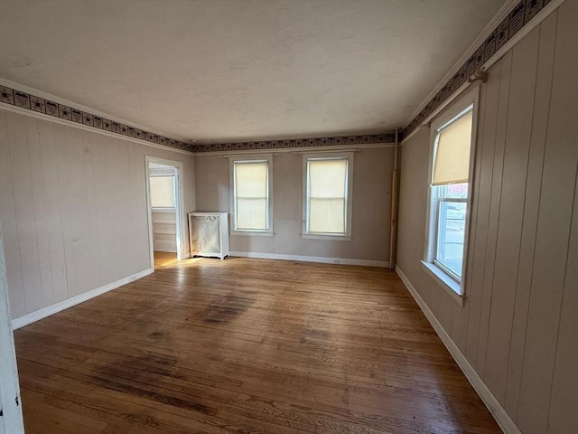 empty room featuring baseboards and wood finished floors