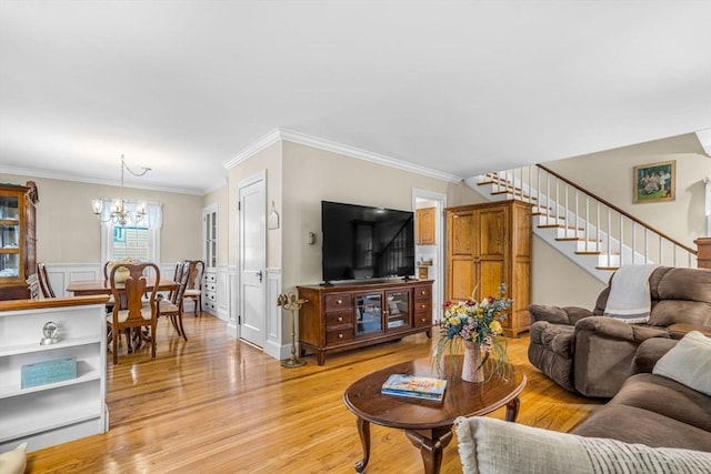 living room featuring crown molding, light hardwood / wood-style floors, and a chandelier