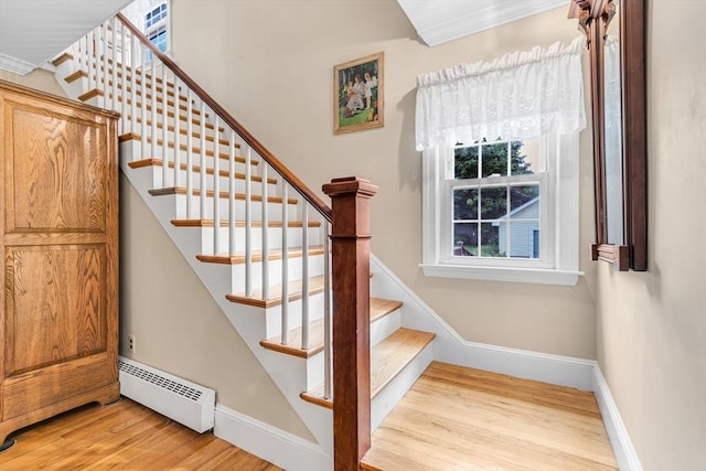 stairway featuring wood-type flooring and baseboard heating