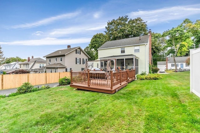 back of property featuring a deck and a lawn