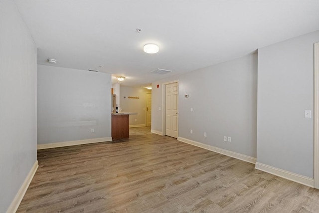 empty room featuring baseboards and light wood-style floors