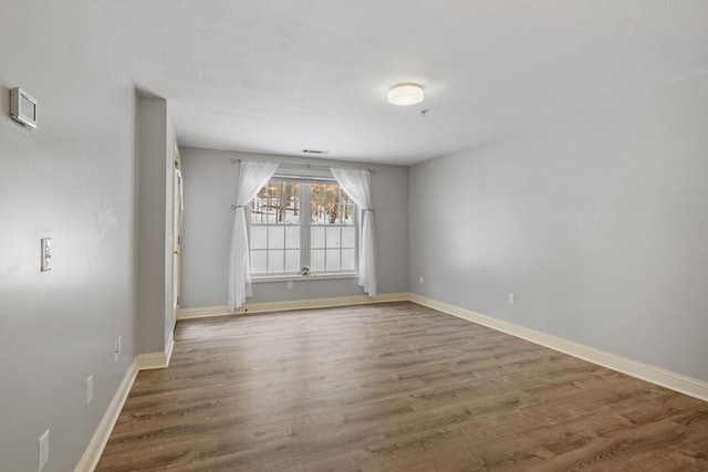 empty room with baseboards and wood finished floors