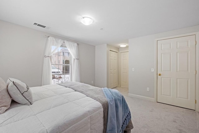 bedroom with light carpet, a closet, visible vents, and baseboards