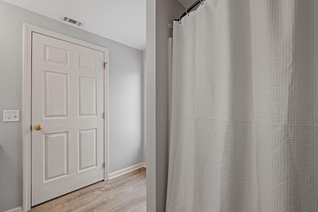 full bath featuring visible vents, baseboards, and wood finished floors