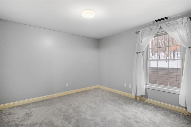 empty room with baseboards, visible vents, and carpet flooring