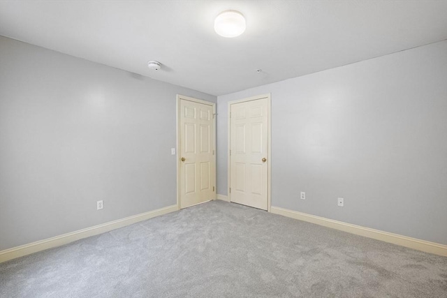 carpeted empty room with baseboards