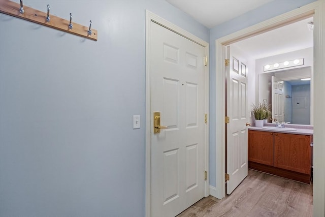 doorway to outside featuring a sink and light wood-style floors