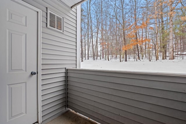 view of snow covered back of property