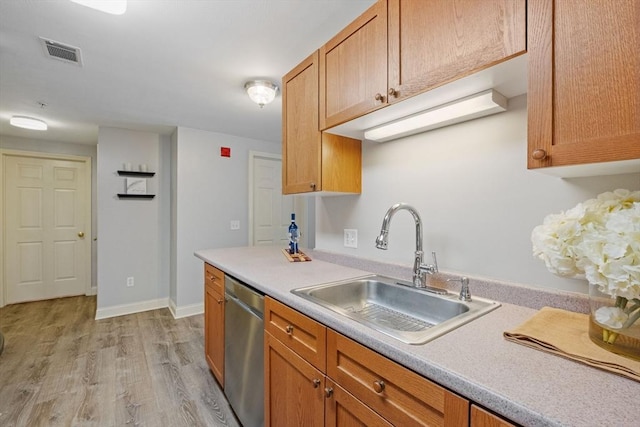 kitchen with light countertops, visible vents, light wood-style flooring, stainless steel dishwasher, and a sink