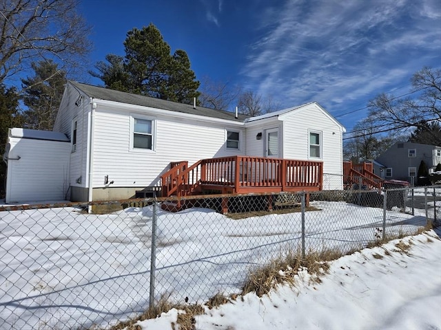 snow covered rear of property featuring fence private yard and a wooden deck