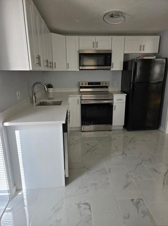 kitchen featuring marble finish floor, white cabinetry, stainless steel appliances, and a sink