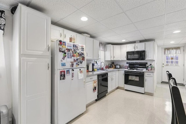 16 Windsor St, Everett, MA 02149 - kitchen with black appliances, a sink, light floors, a drop ceiling, and light countertops