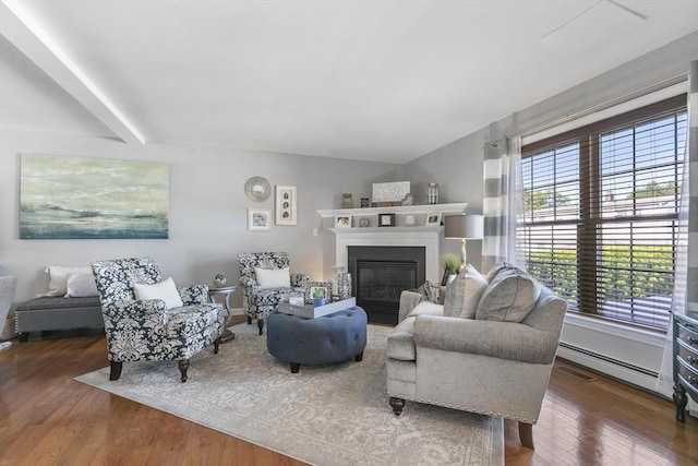 16 Windsor St, Everett, MA 02149 - living room featuring a baseboard heating unit, wood finished floors, a glass covered fireplace, and beam ceiling