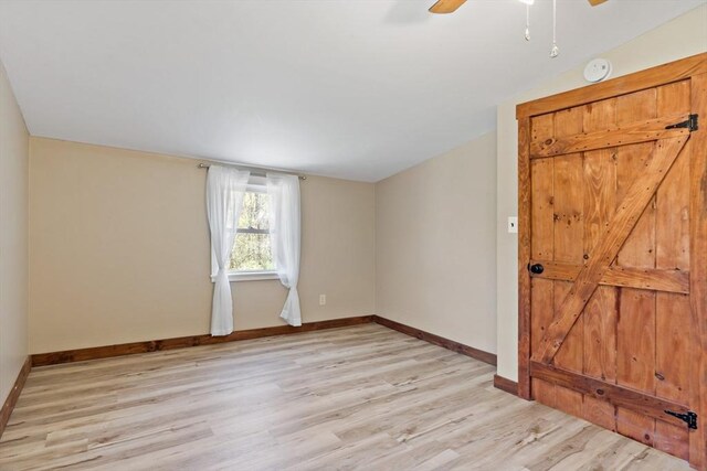 empty room featuring light wood-style floors, baseboards, and ceiling fan