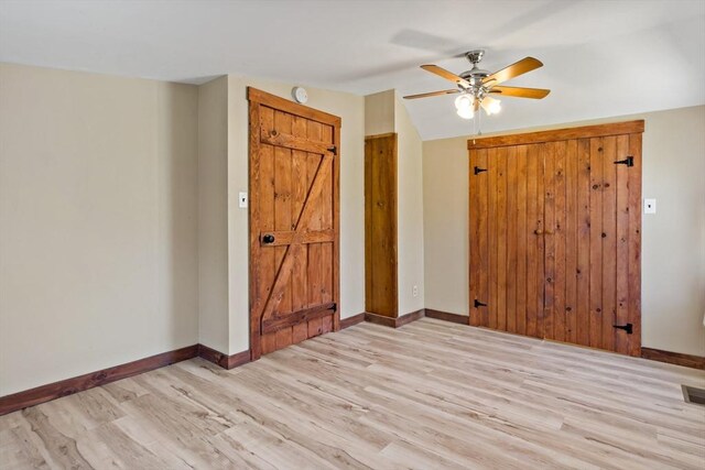 spare room featuring a ceiling fan, baseboards, and light wood-style floors