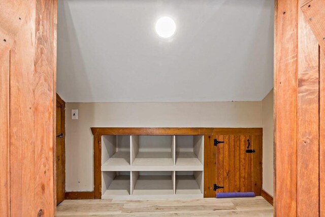 bonus room with baseboards, vaulted ceiling, and wood finished floors