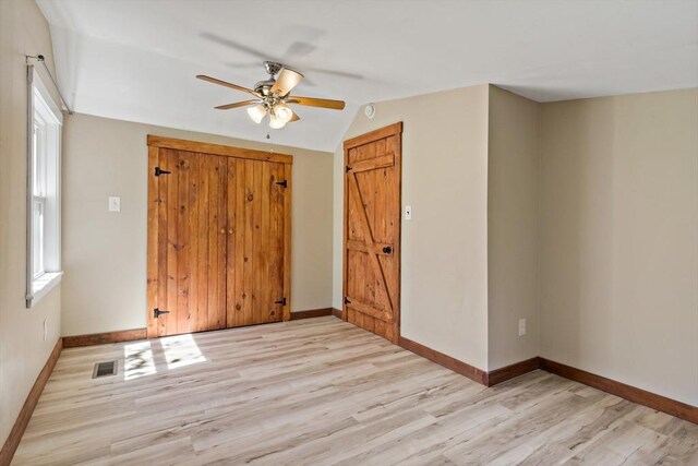 interior space with light wood-style floors, baseboards, a ceiling fan, and a wealth of natural light