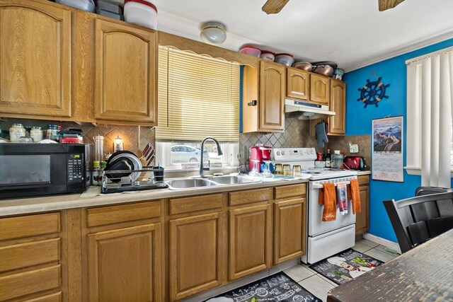kitchen featuring electric range, light tile patterned flooring, black microwave, a sink, and under cabinet range hood