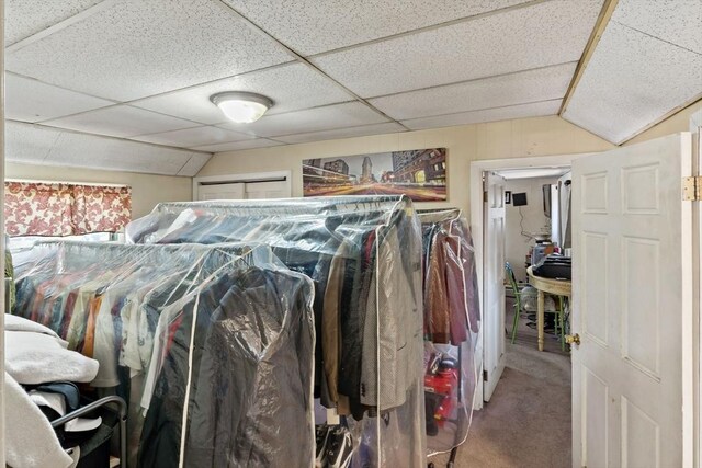 carpeted bedroom with a paneled ceiling and lofted ceiling