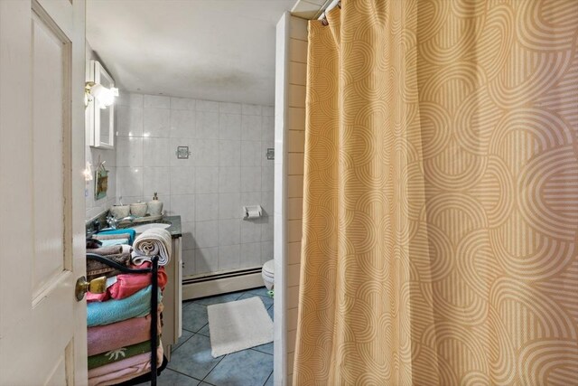full bath featuring vanity, tile patterned floors, a baseboard heating unit, and tile walls