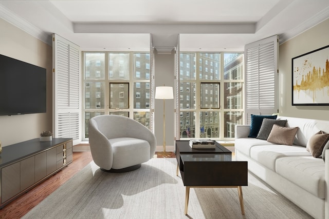 living room with floor to ceiling windows, light wood-type flooring, and crown molding