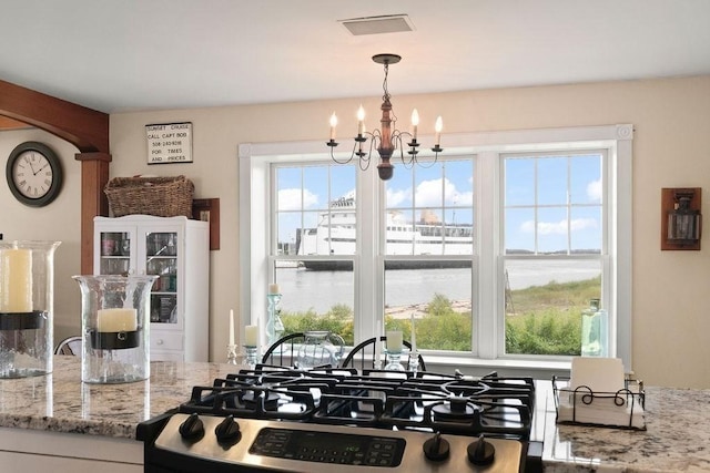 107 Channel Point Rd, Barnstable, MA 02601 - kitchen with range, a water view, a chandelier, light stone countertops, and hanging light fixtures