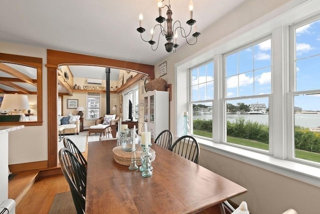 107 Channel Point Rd, Barnstable, MA 02601 - dining area with a water view, a baseboard radiator, light wood-type flooring, a chandelier, and arched walkways