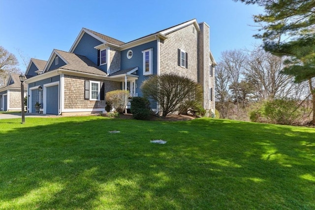 2 Englewood Dr Unit Jl, Harwich, MA 02645 - view of front of home featuring a chimney, a front lawn, and an attached garage