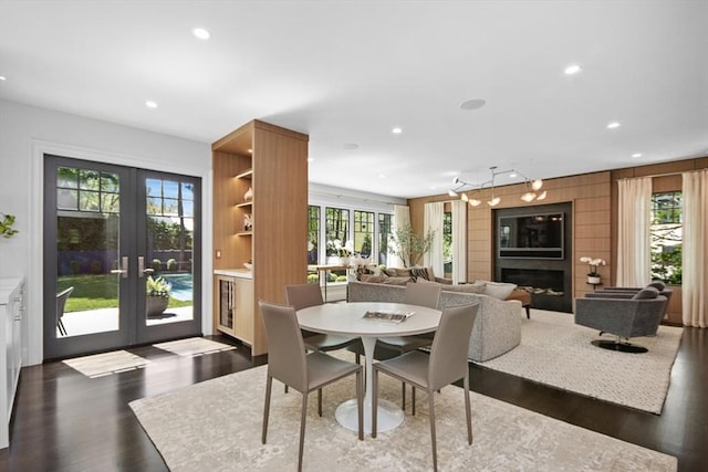 dining room featuring a fireplace, recessed lighting, french doors, and dark wood finished floors