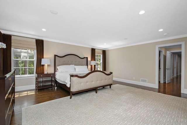 bedroom with crown molding, baseboards, visible vents, and wood finished floors