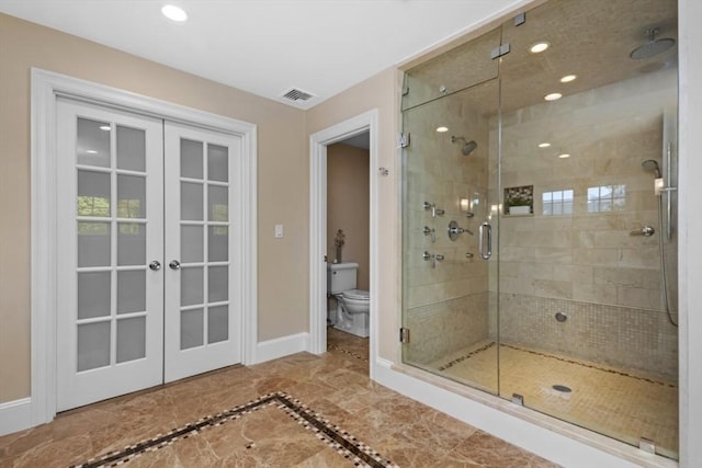 bathroom with toilet, french doors, visible vents, a stall shower, and baseboards