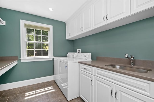 clothes washing area featuring a sink, cabinet space, recessed lighting, separate washer and dryer, and baseboards