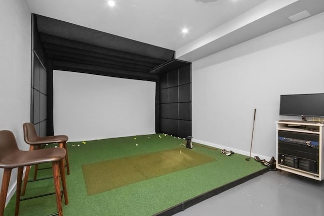 playroom featuring golf simulator, concrete floors, and baseboards