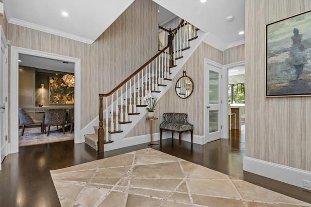entrance foyer featuring stairway, ornamental molding, wallpapered walls, and wood finished floors