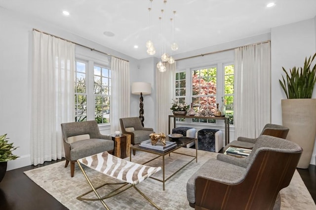living area featuring baseboards, a chandelier, recessed lighting, and wood finished floors