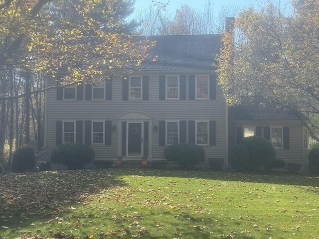 colonial home featuring a front lawn