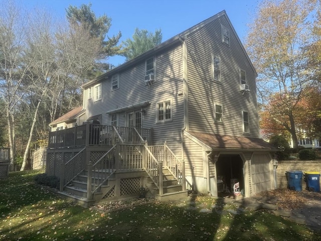 back of house featuring a yard, a garage, and a wooden deck