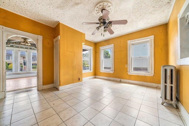 24 N Byron Ave, Brockton, MA 02301 - empty room with ceiling fan, light tile patterned floors, and radiator