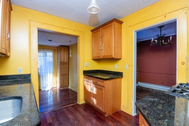 kitchen with dark wood-type flooring, a textured ceiling, and sink