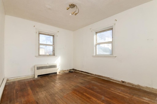 unfurnished room featuring dark hardwood / wood-style floors and radiator