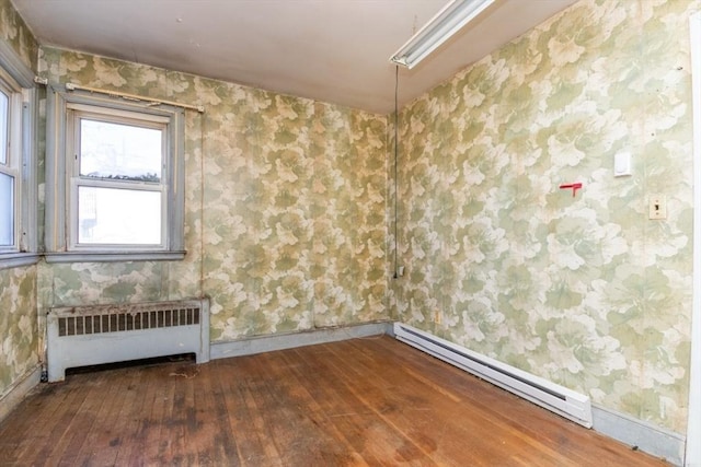 unfurnished room featuring radiator, baseboard heating, and hardwood / wood-style floors