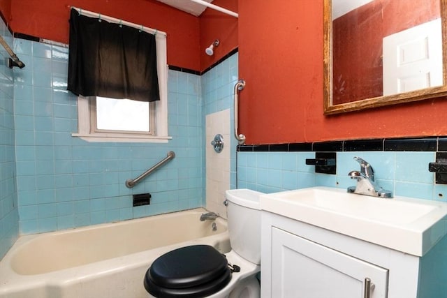 full bathroom featuring vanity, toilet, tile walls, and tiled shower / bath