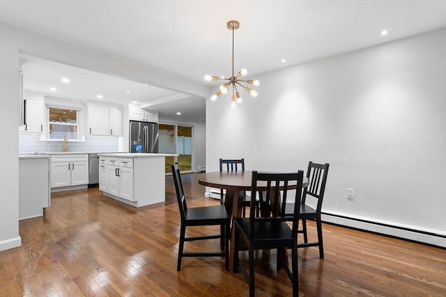 dining area featuring dark wood-style floors, recessed lighting, and a chandelier