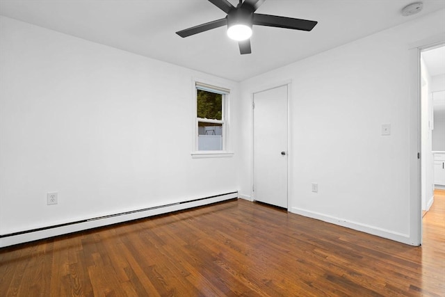 spare room featuring baseboard heating, a ceiling fan, a smoke detector, and wood finished floors