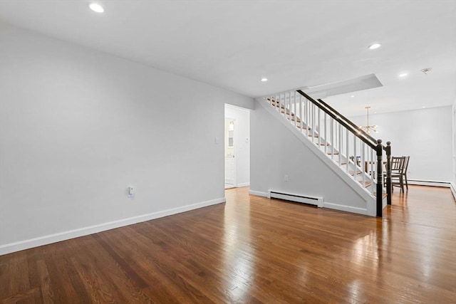 unfurnished living room featuring baseboard heating, a chandelier, stairway, recessed lighting, and wood finished floors